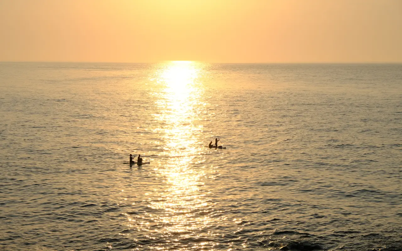 Precioso atardecer en Mallorca con personas haciendo paddle surf