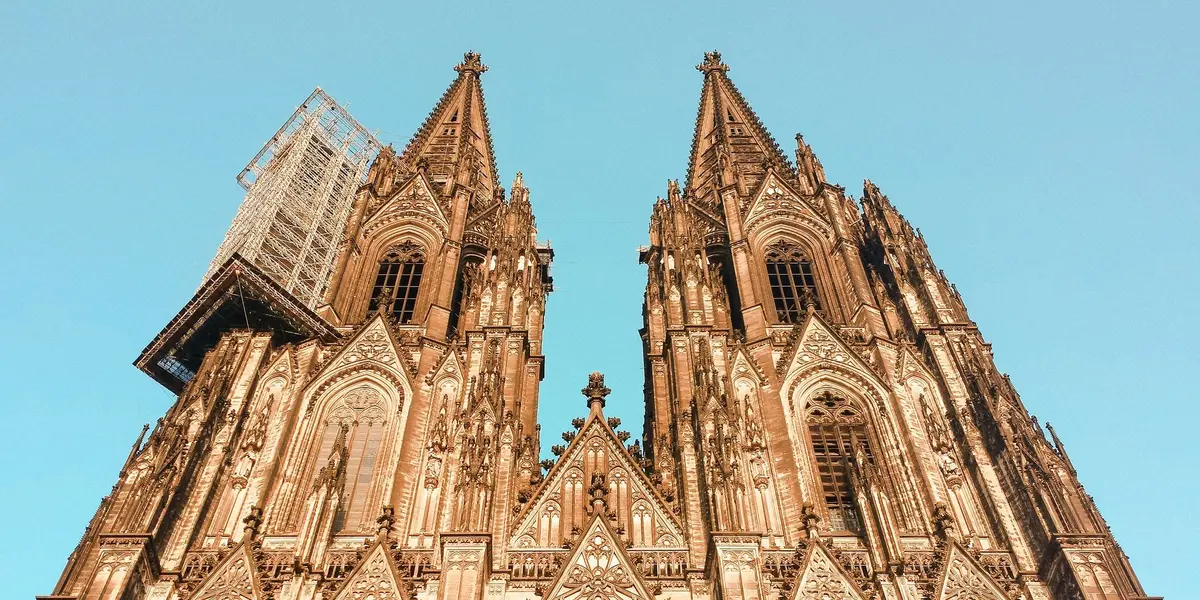 Torres gemelas de la Catedral de Colonia, Alemania, con detalles góticos y andamiaje en una de las fachadas.