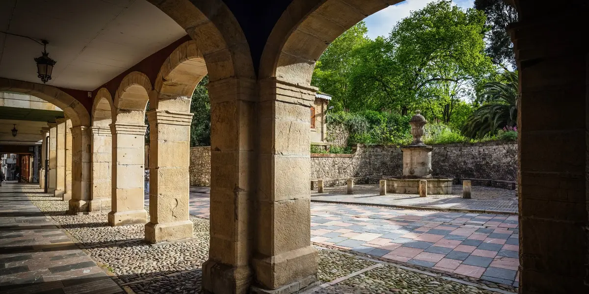 Soportales de piedra y fuente en el casco histórico de Avilés