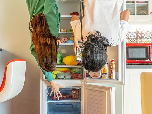 Dos personas posan del revés en la cocina del Big Fun Museum de Barcelona