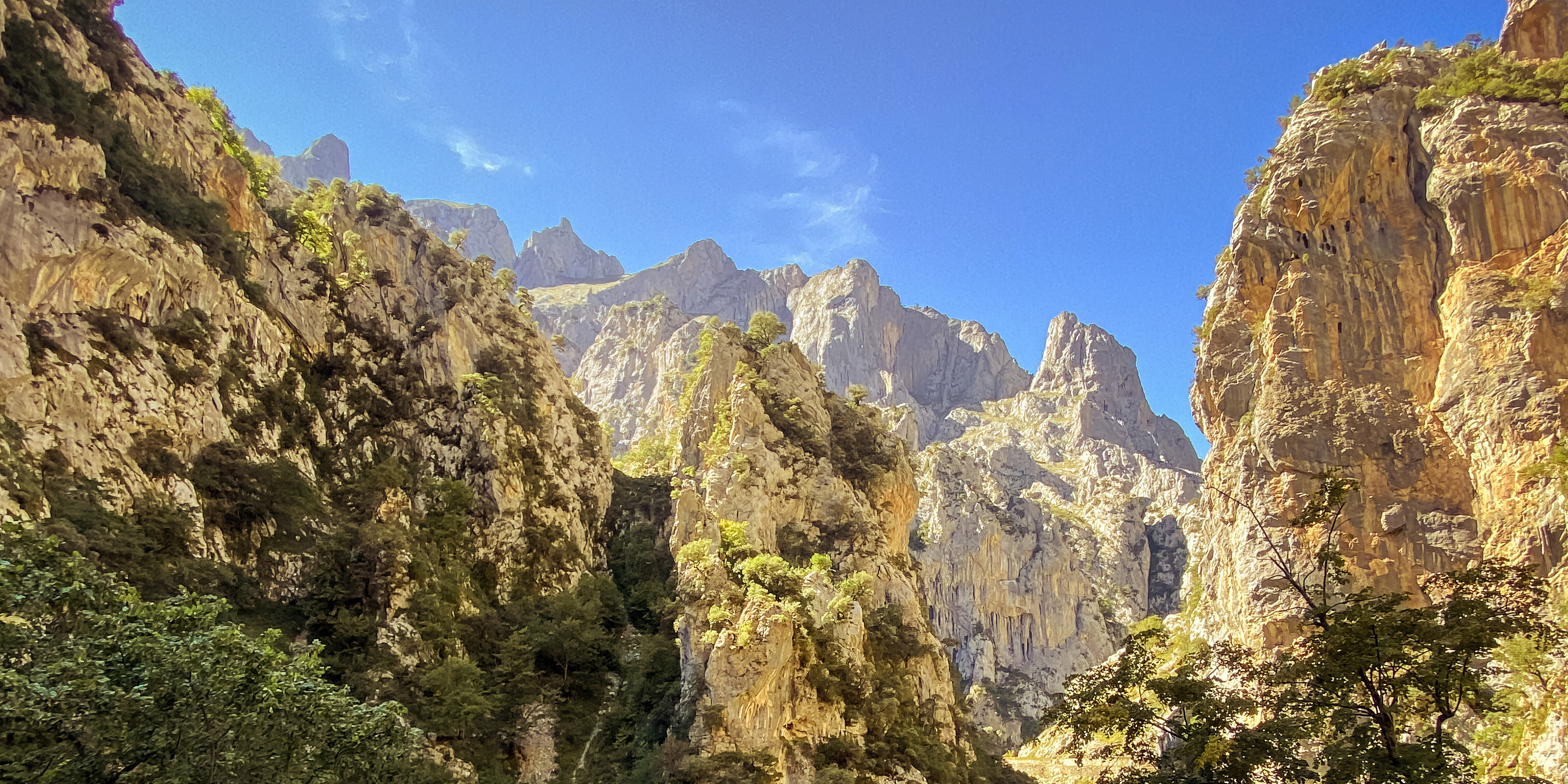 Paisaje de montañas escarpadas y desfiladero iluminado por el sol en la Ruta del Cares.