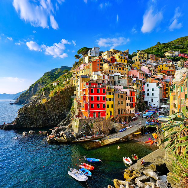 Vista de las coloridas casas a lo largo de la costa de la zona de Cinque Terre en Riomaggiore -  Excursión a Cinque Terre con Paseo en Barco desde Milán - Actividades y Excursiones Buendía Milán, Italia