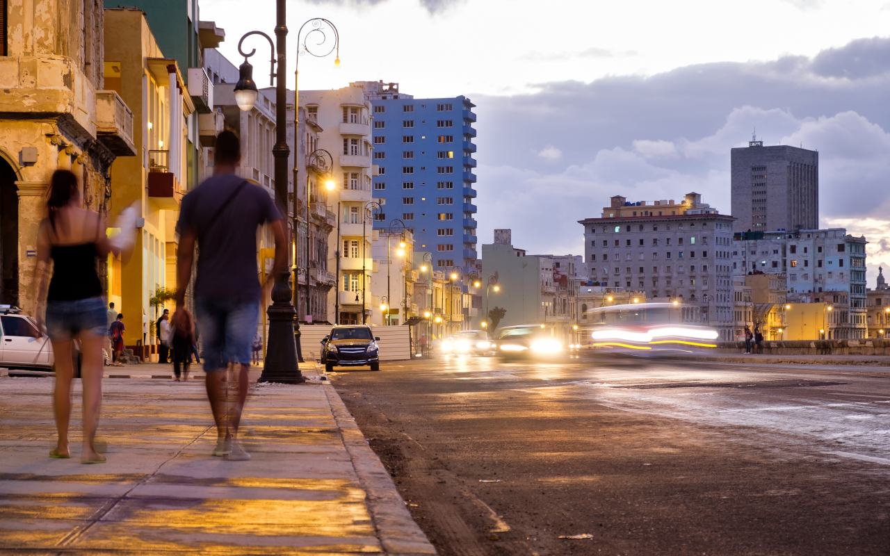 Pareja caminando al atardecer por La Habana, en una ruta de bares y baile