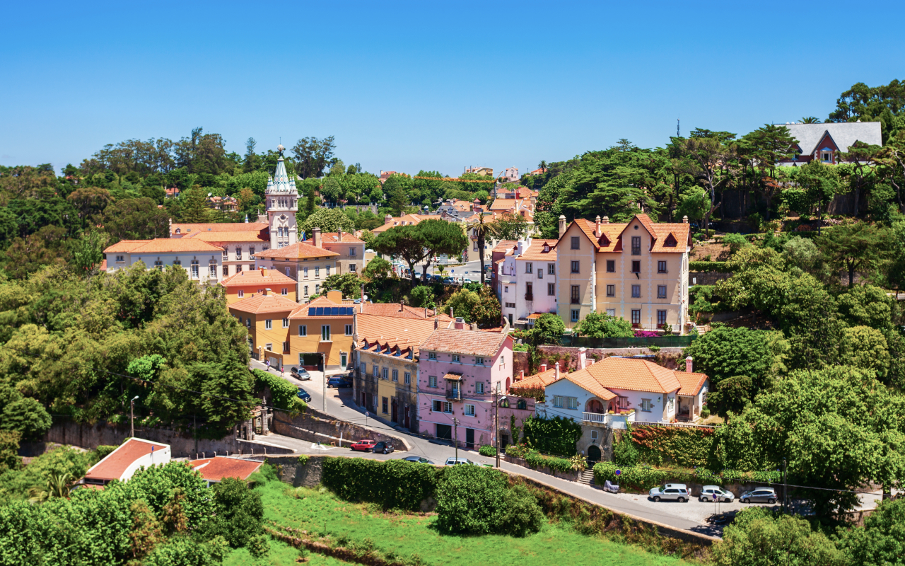 Vista aérea de Sintra con casas coloridas, vegetación y la torre del ayuntamiento.