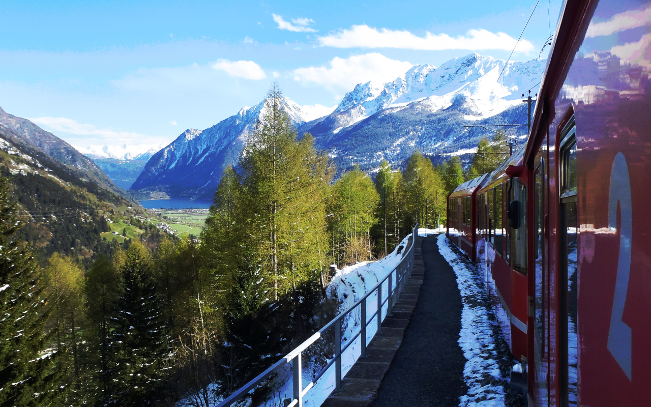 Tren Bernina pasando entre montañas y paisajes nevados de camino a Tirano.