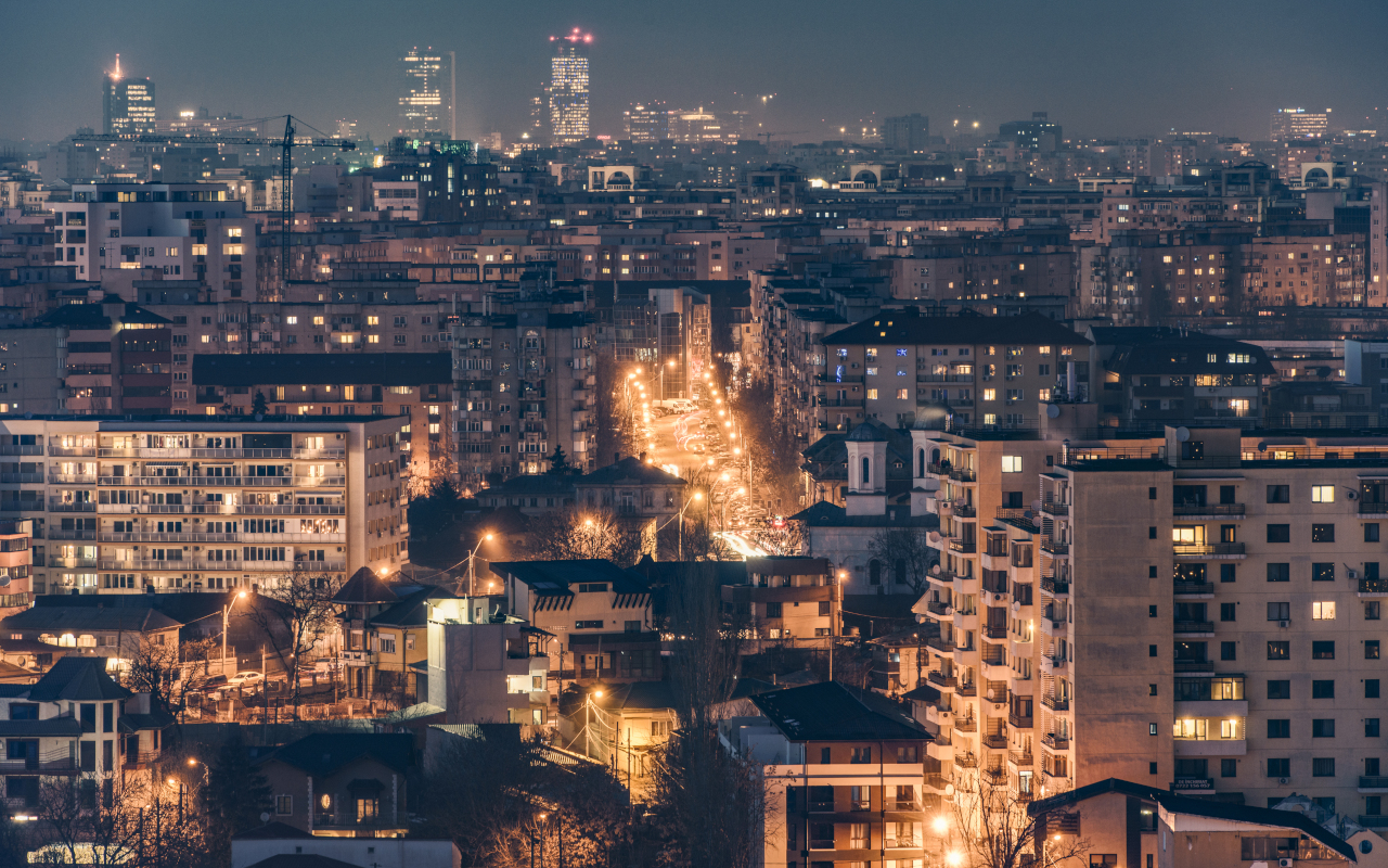 Vista aérea nocturna de Bucarest con las calles y edificios iluminados.