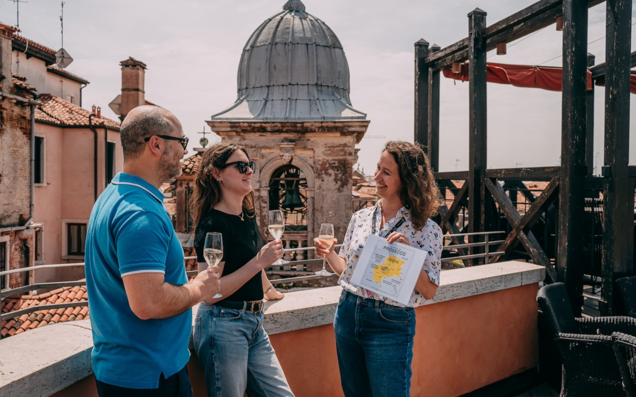 La guía y los turistas brindando con Prosecco desde las alturas.