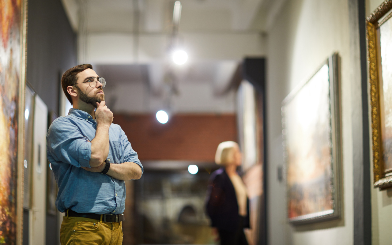 Visitante contemplando el arte que cuelga de las paredes.