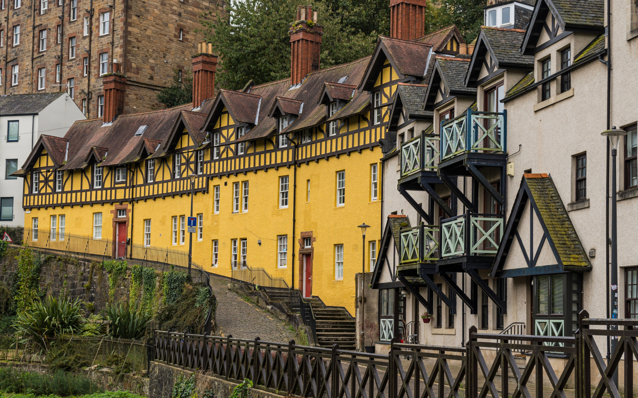 ista de la arquitectura típica de Dean Village, con sus casas de piedra de estilo escocés y tejados a dos aguas, rodeadas de naturaleza.
