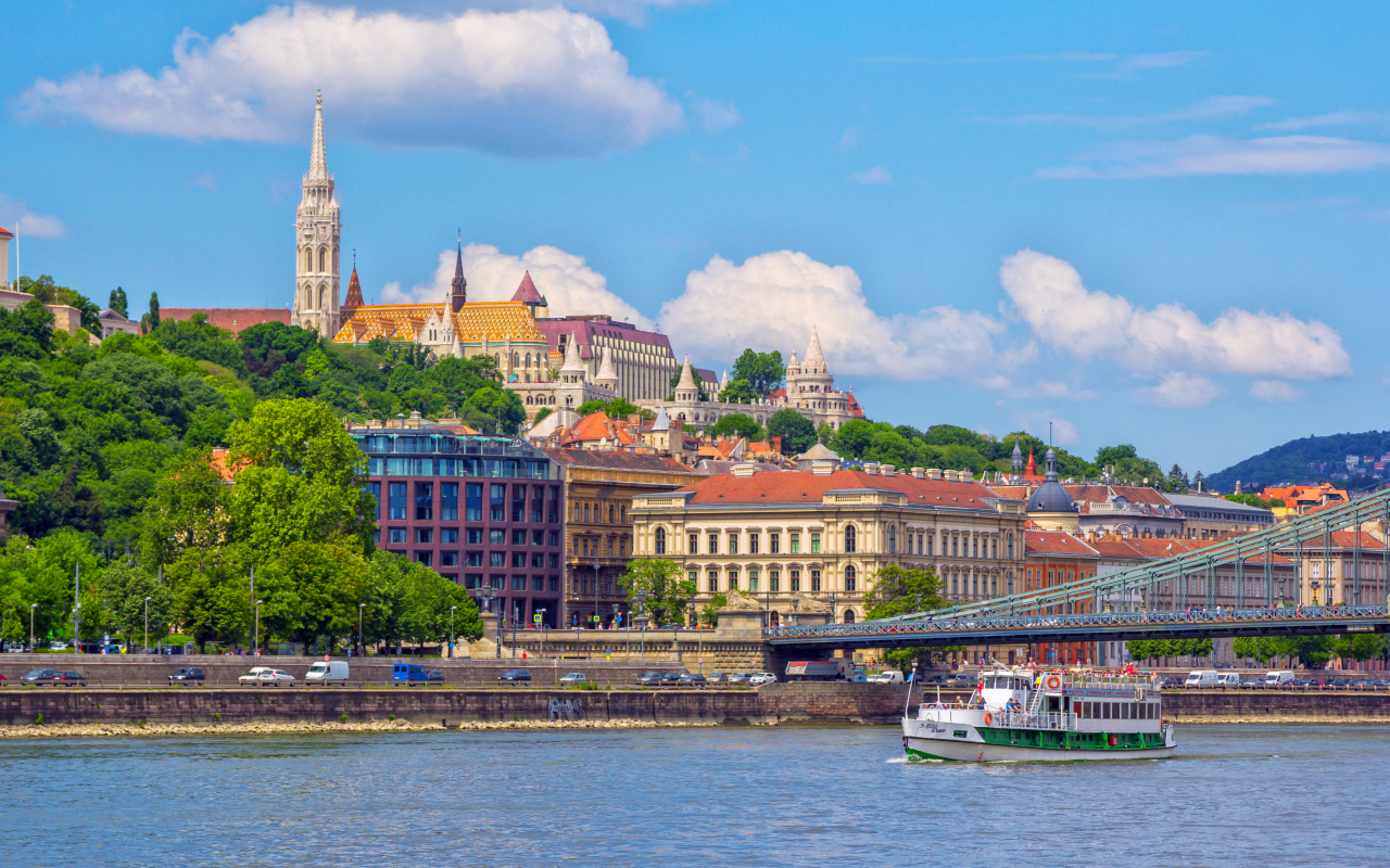 Paisaje urbano de Budapest con la embarcación en la que se realizará el crucero por el Danubio.