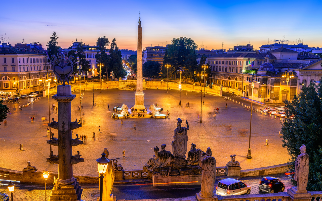 Piazza del Popolo a la luz de las farolas romanas, siendo el punto de origen de este free tour.