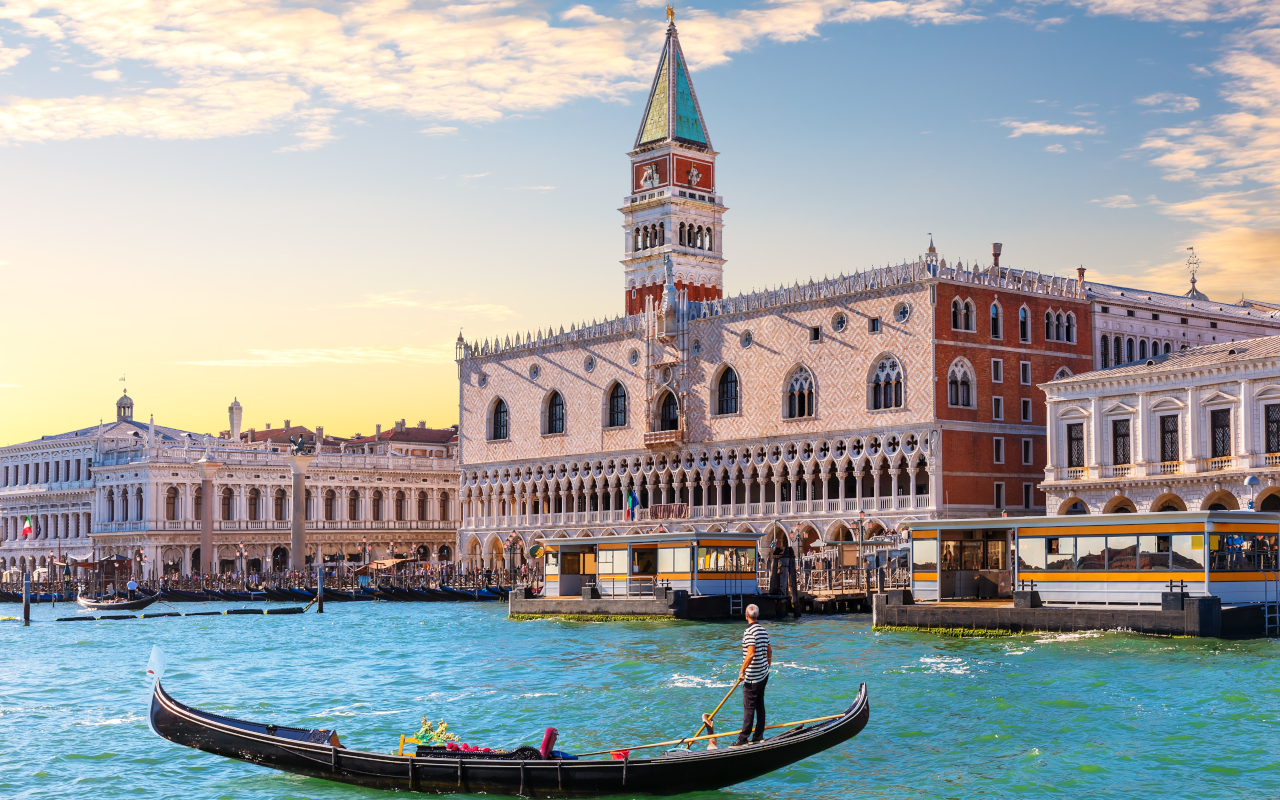 Vista desde una góndola en la Plaza de San Marcos, con la arquitectura histórica y los turistas disfrutando del ambiente veneciano.