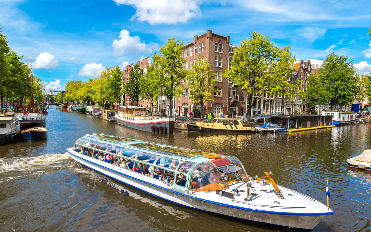 Barco de turismo en los canales de Ámsterdam en día soleado