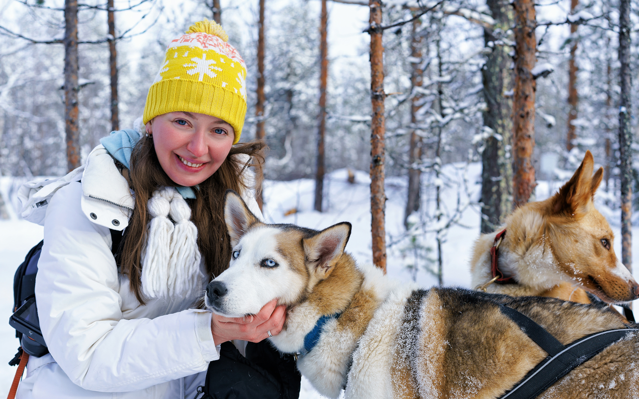 Una joven acaricia a los huskies antes de iniciar su paseo por el paraíso invernal.