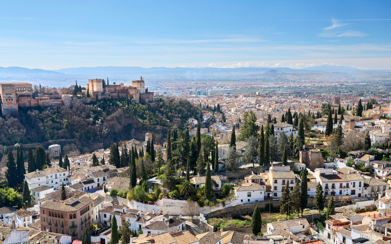 Desde las colinas del Albaicín, se divisan las casas cueva del Sacromonte, creando un paisaje único que mezcla historia y tradición.