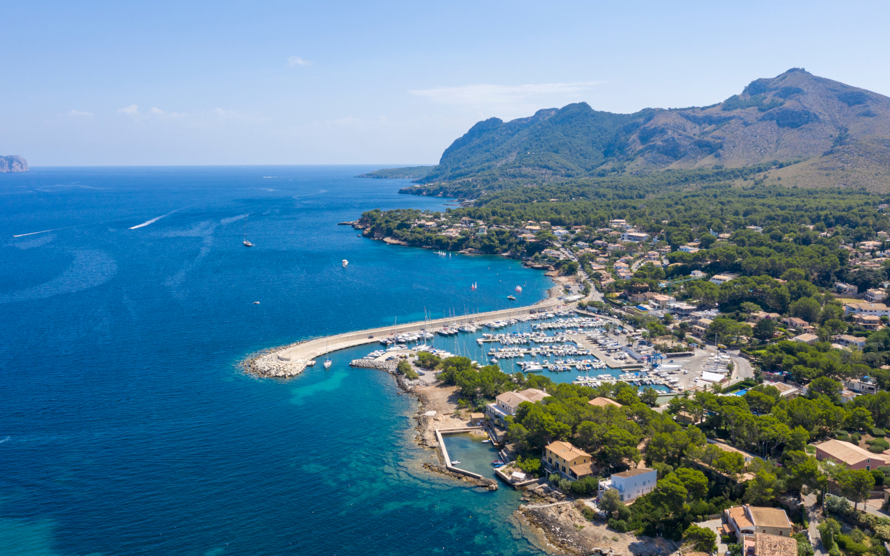 Panorámica de la costa de Alcudia, con sus aguas cristalinas, playas de arena dorada y un paisaje natural impresionante que se extiende hacia el horizonte.