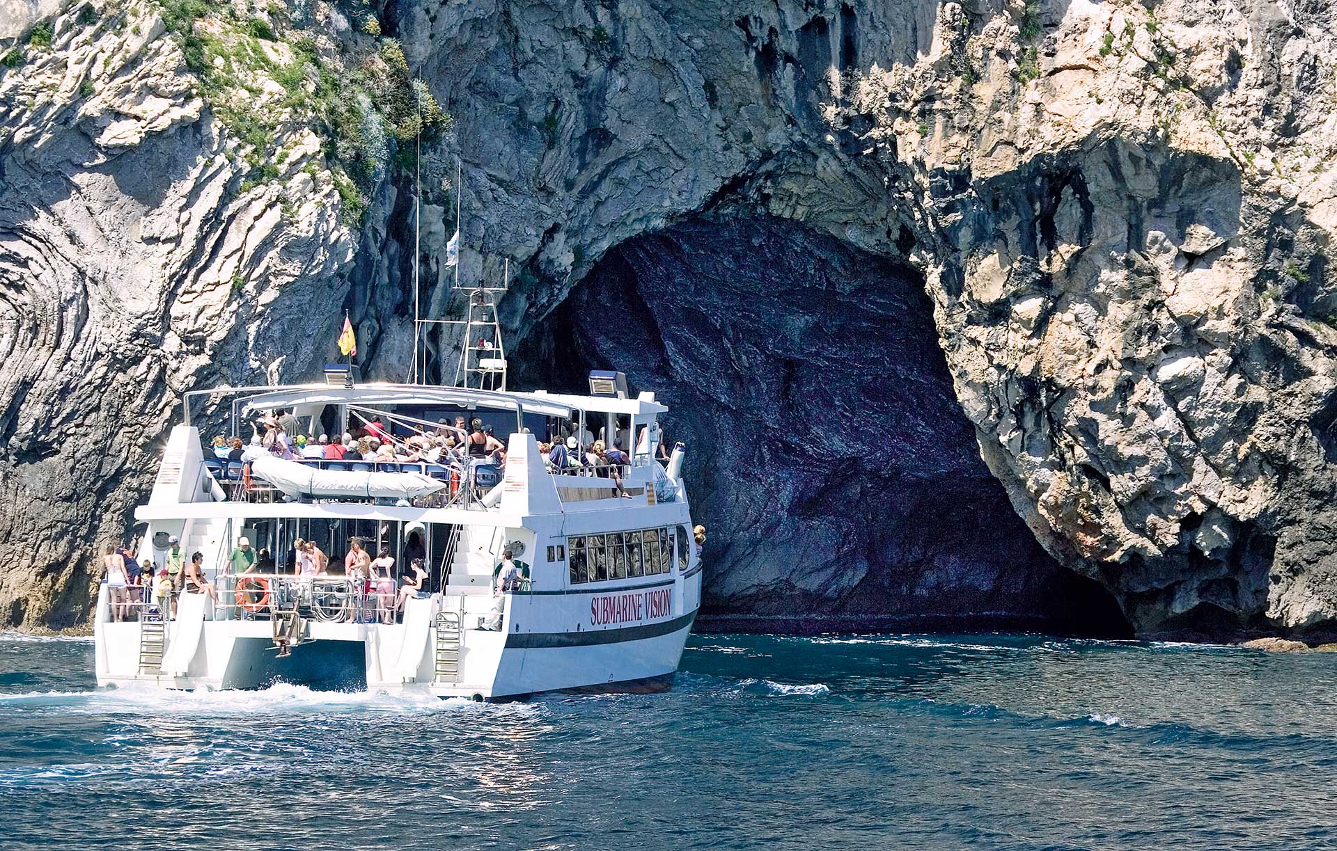 El barco avanza entre formaciones rocosas, ofreciendo una vista única del paisaje costero de la isla.