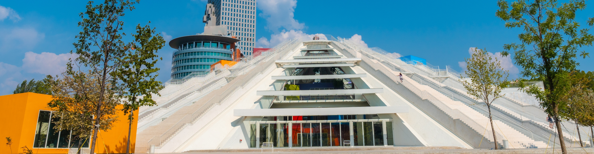 Vista de la Pirámide de Tirana, destacando su estructura inconfundible y su diseño futurista, rodeada de la ciudad.