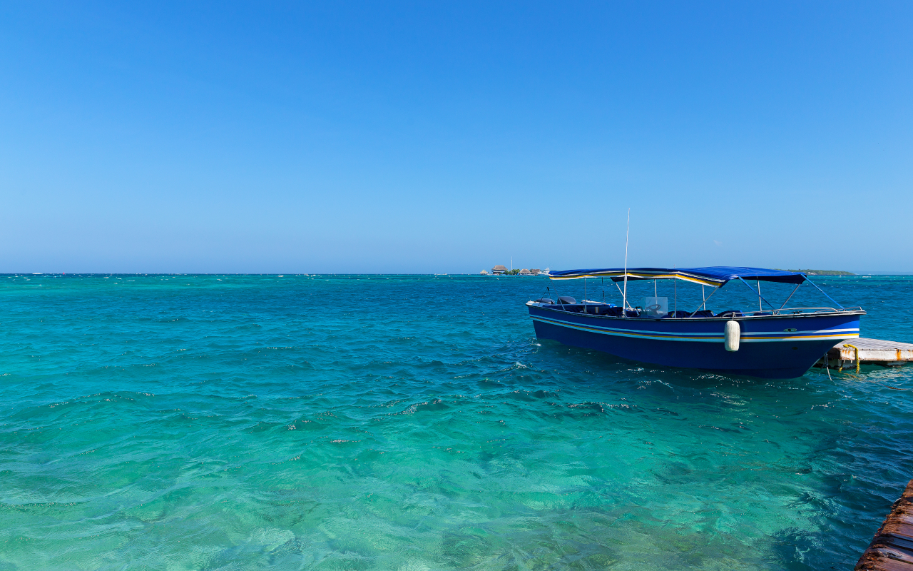 Barca de transporte en las aguas cristalinas del Parque Natural Corales de Rosario, Colombia