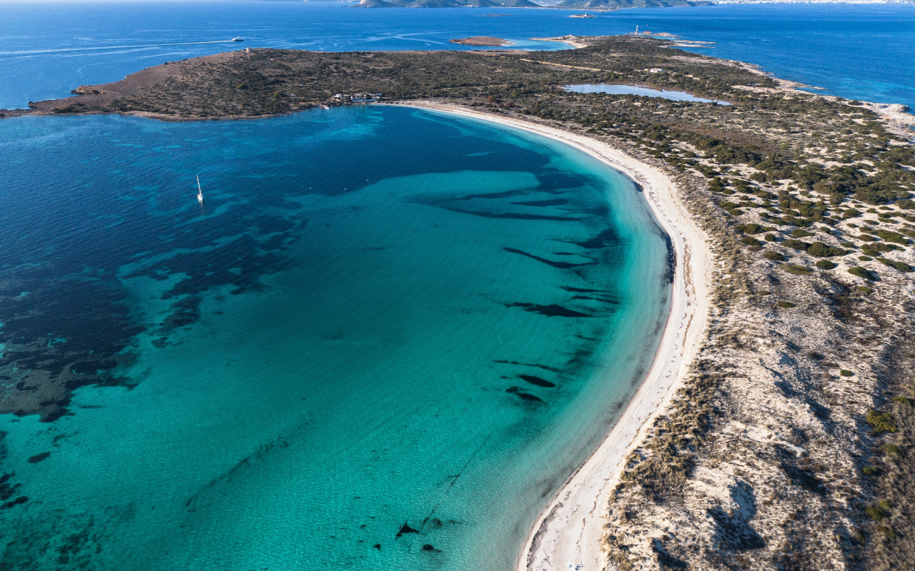 Vista érea de la isla de Espalmador, con el contrate azul intenso y turquesa de sus aguas.