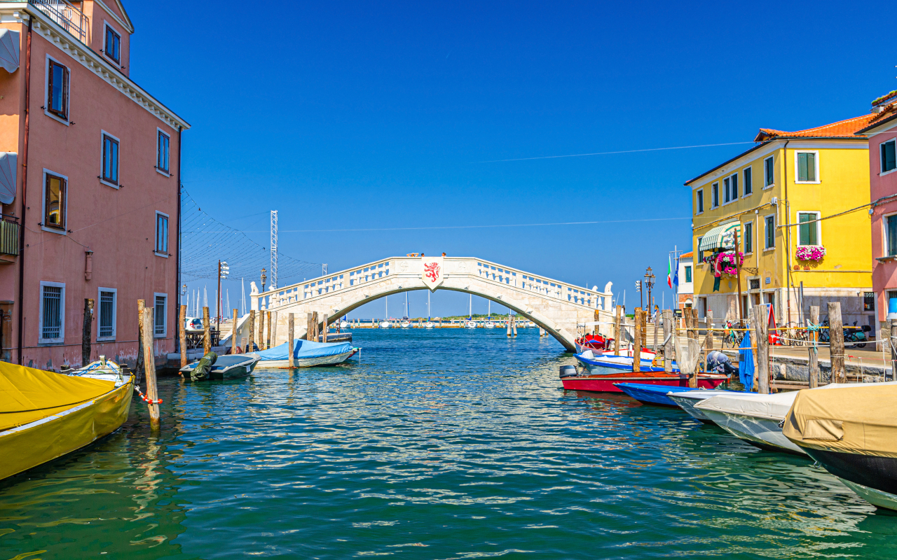 Puente blanco que forma parte del paisaje acuático de Chioggia.