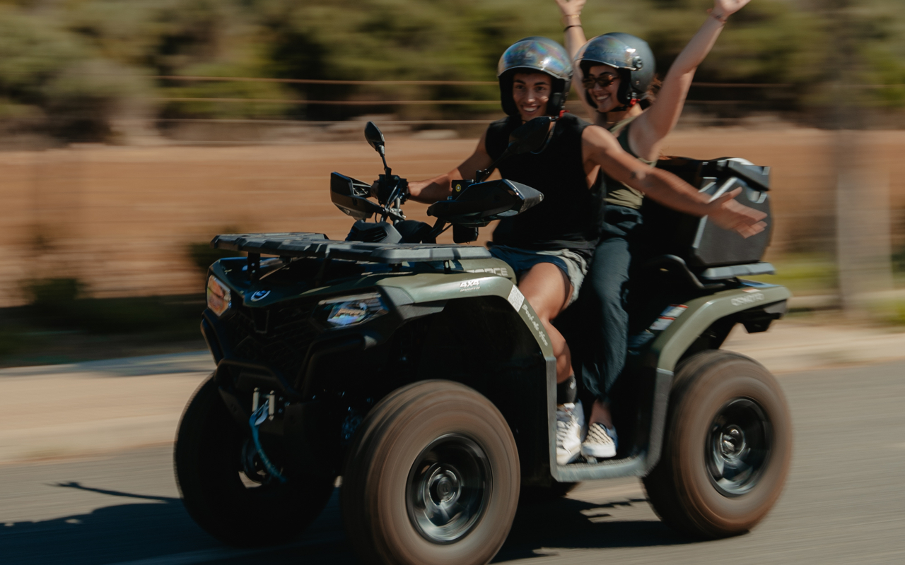 Diversión a bordo de un quad de una pareja sintiendo la adrenalina y la velocidad.
