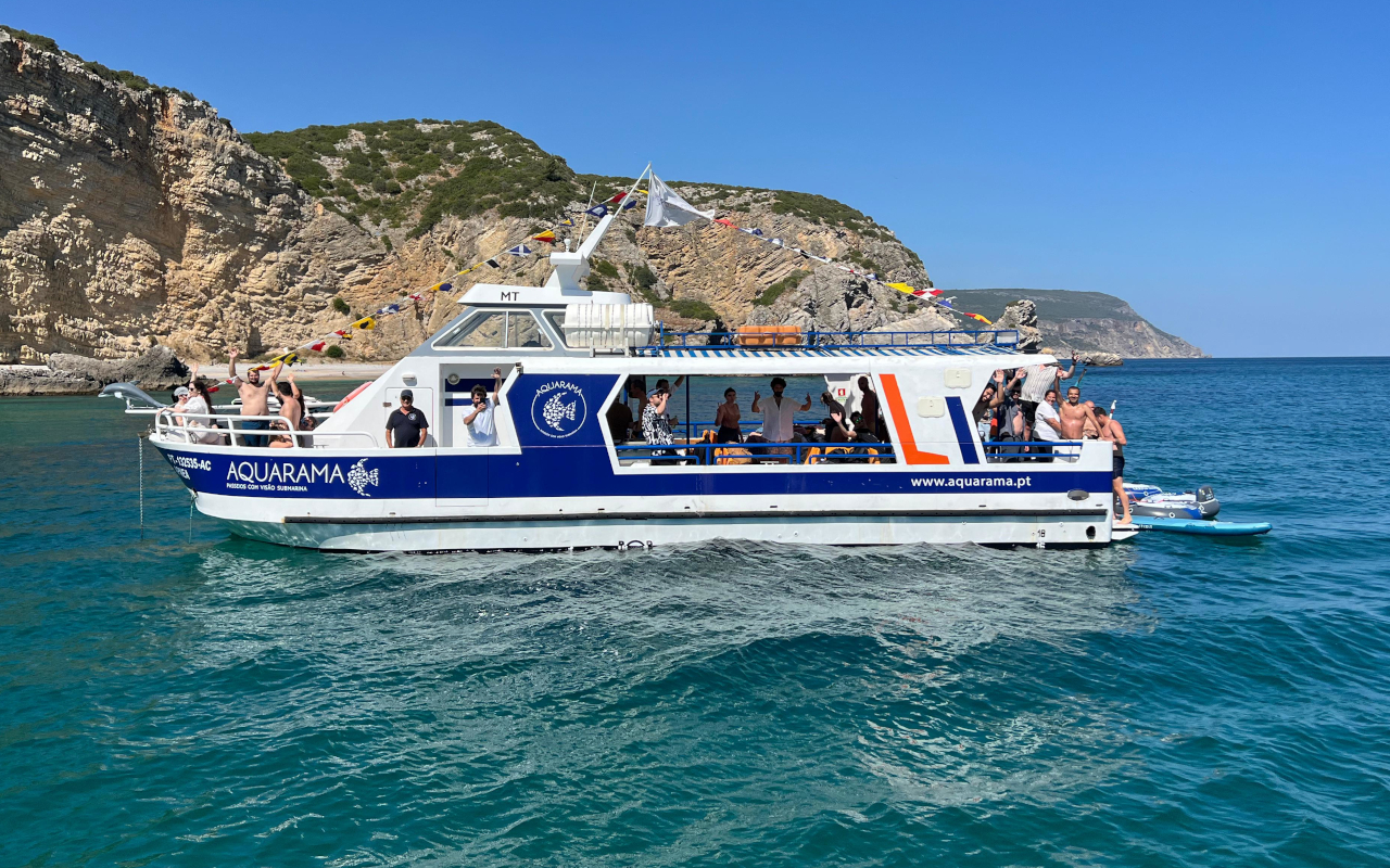 El barco con visión submarina navega entre aguas cristalinas y paisajes de postal.