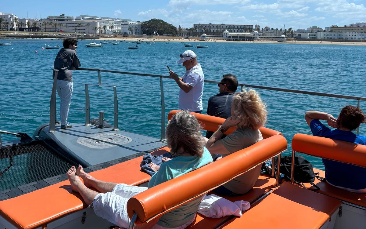 Grupo de personas disfruta del sol en un catamarán en la bahía de Cádiz