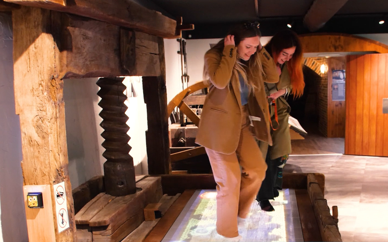 Chicas divirtiéndose en el Museo del vino de Alsacia con los pies descalzos.