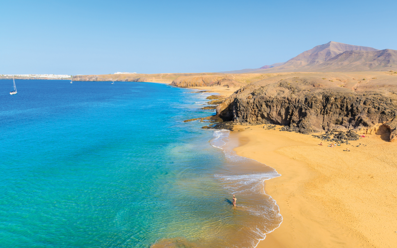 Al otro lado del agua, una curva perfecta de arena dorada resiste intacta el paso del tiempo: la playa de Papagayo.