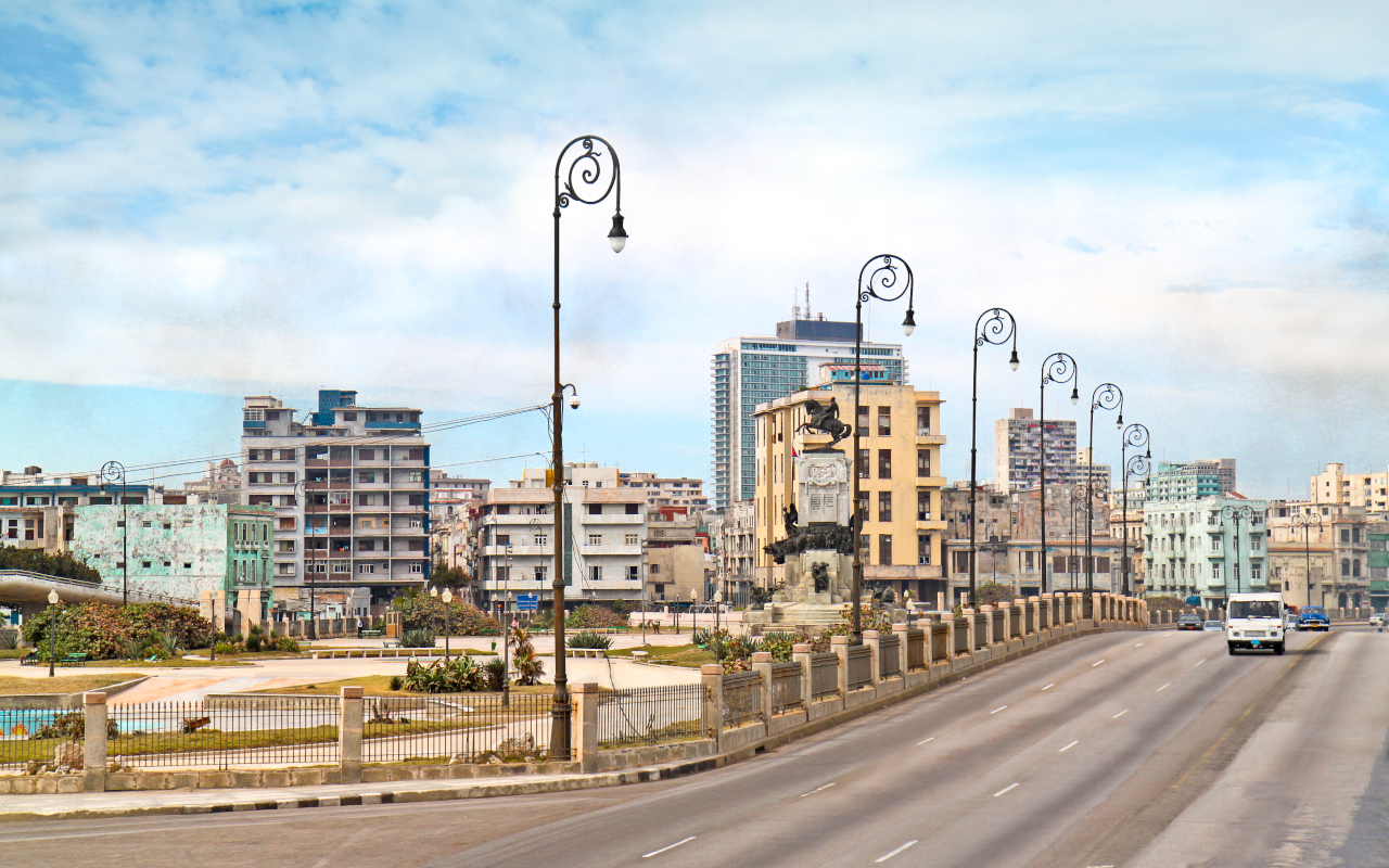 Perspectiva de la Quinta Avenida de La Habana, flanqueada por palmeras y mansiones históricas.