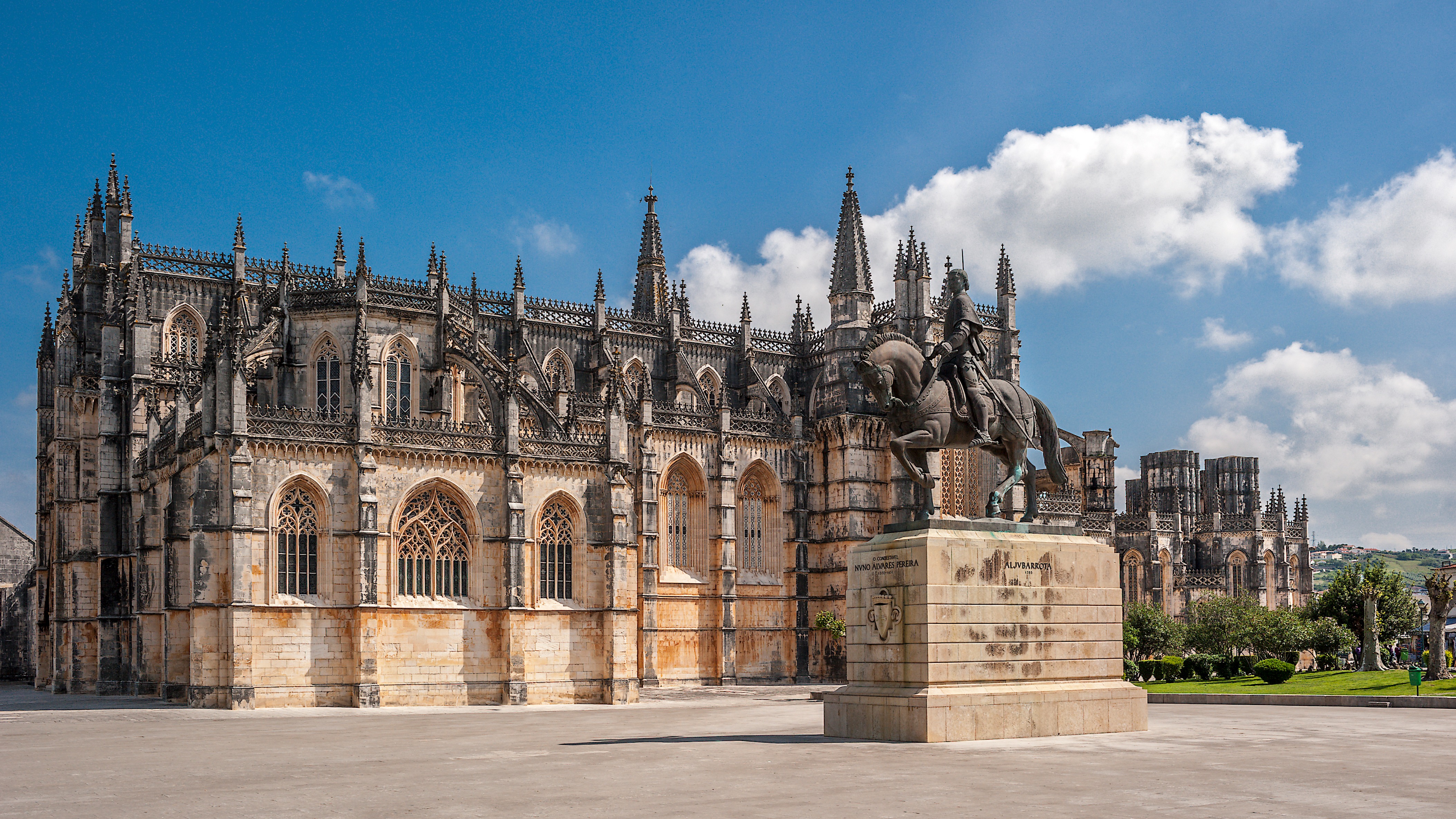 Monasterio de Santa María de la Victoria, Batalha, Portugal, con arquitectura gótica y estatua ecuestre.