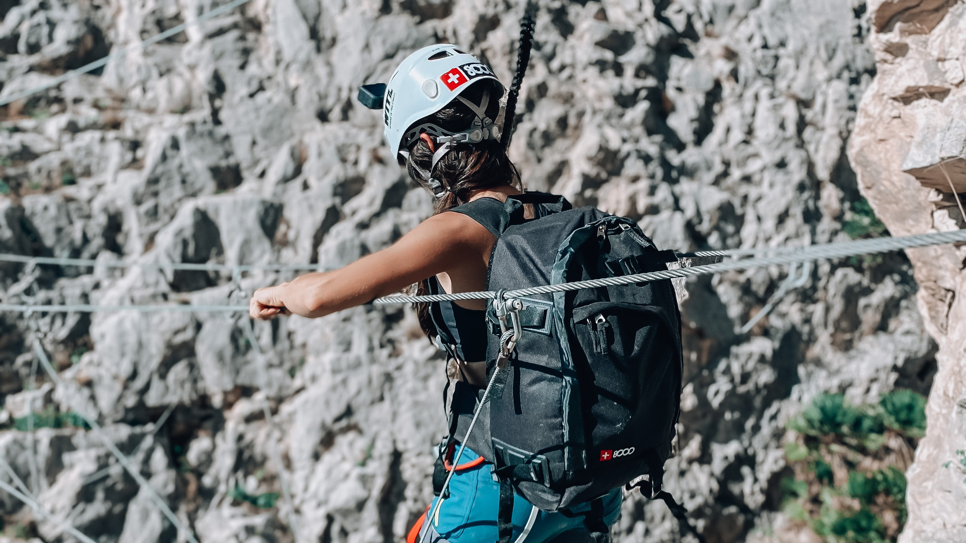 Escaladora asegurada con mosquetón en la vía ferrata de El Chorro, Málaga.
