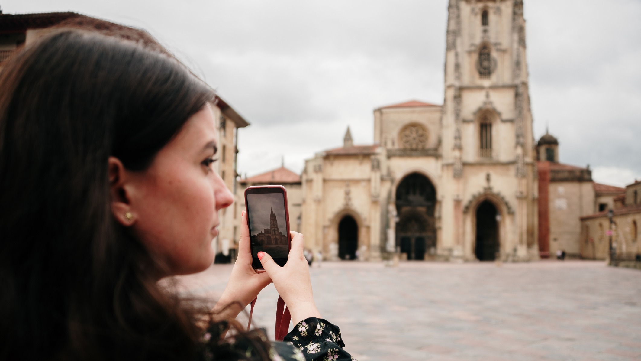 Turista fotografiando la Catedral de San Salvador de Oviedo con su móvil durante una visita al casco histórico de la ciudad.
