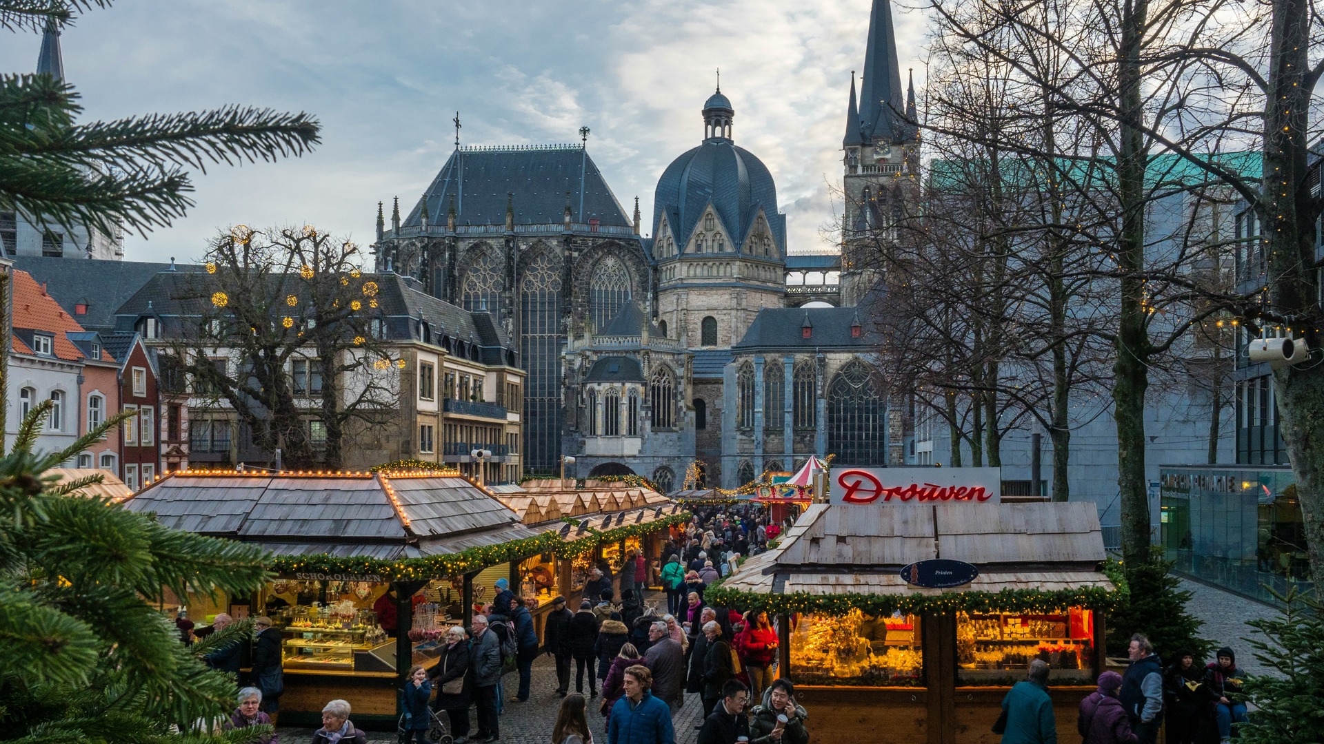 Mercado navideño en Aquisgrán con la Catedral (Aachener Dom) con cúpula oscura al fondo.