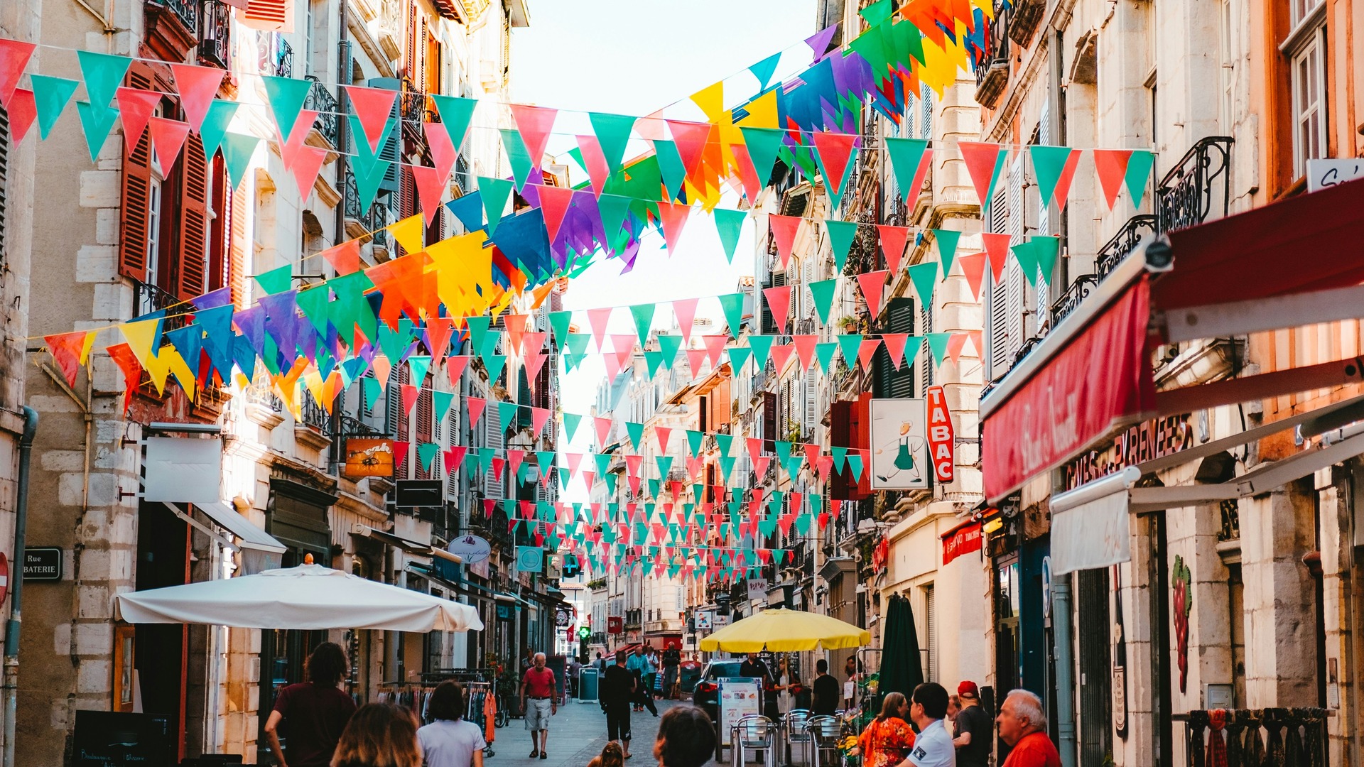 Calle de Bayona decorada con banderines de colores durante ambiente festivo.