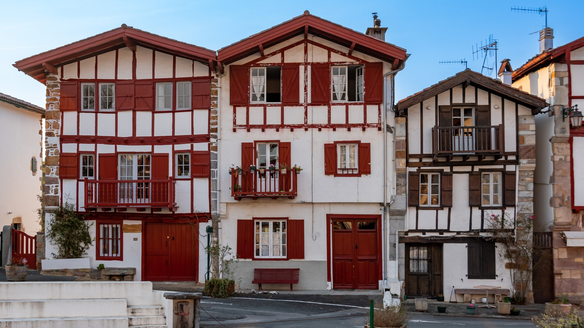 Casas tradicionales con entramado de madera y contraventanas rojas en el centro de Ainhoa.