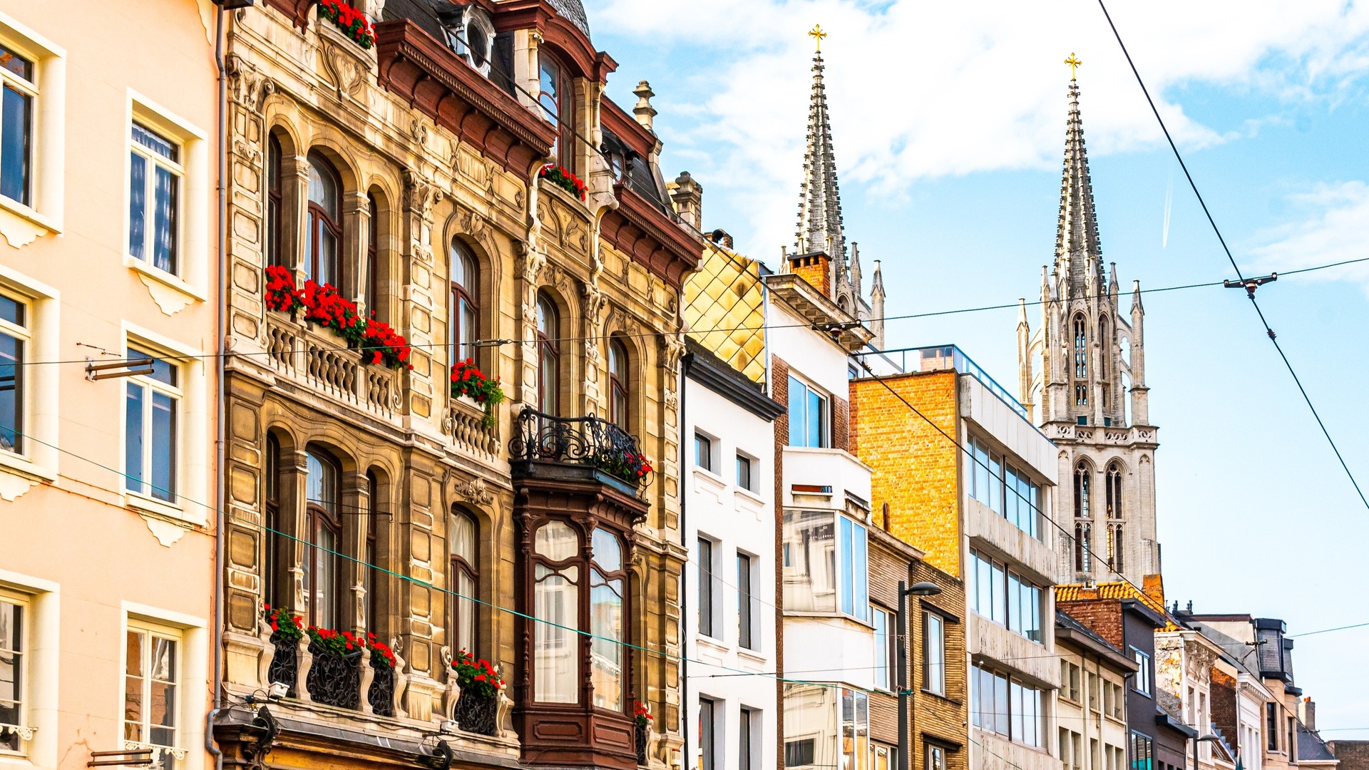 Fachadas históricas y torre gótica en una calle del centro de Amberes, Bélgica