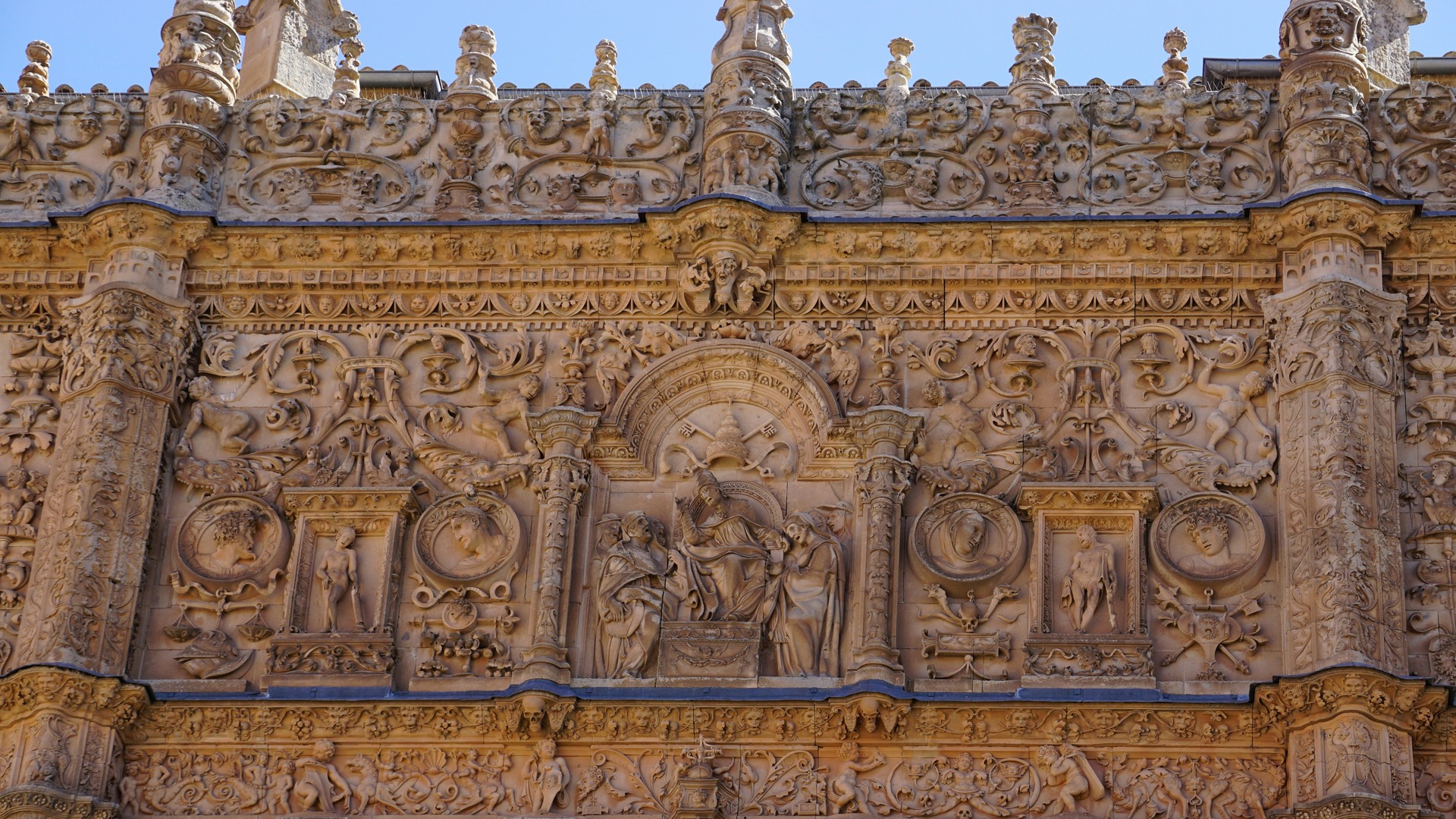 Detalle de la fachada plateresca de la Universidad de Salamanca, repleta de relieves y esculturas históricas.