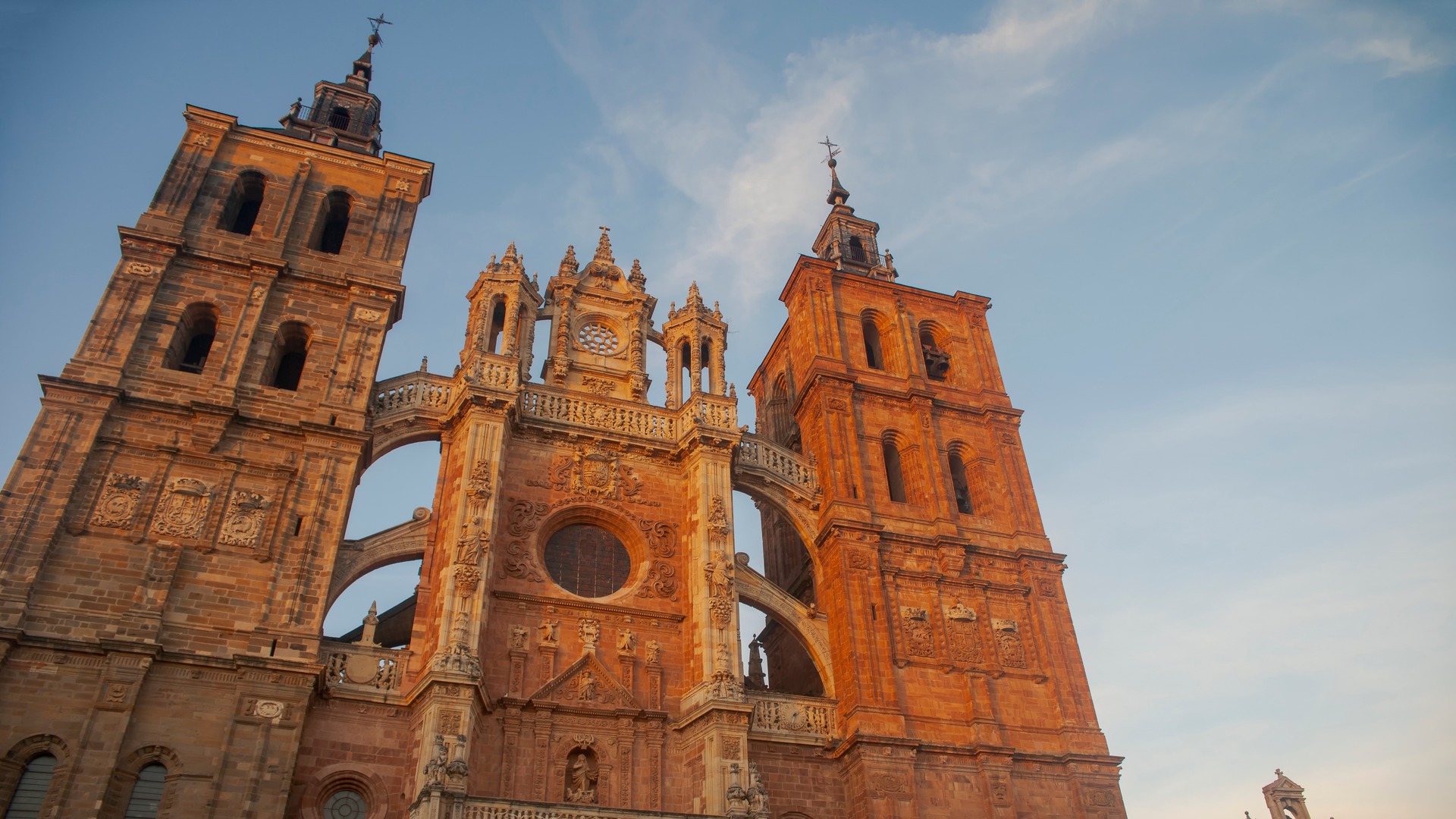 Fachada de la Catedral de Astorga, León, arquitectura gótica y barroca, torres gemelas al atardecer, contrapicada.