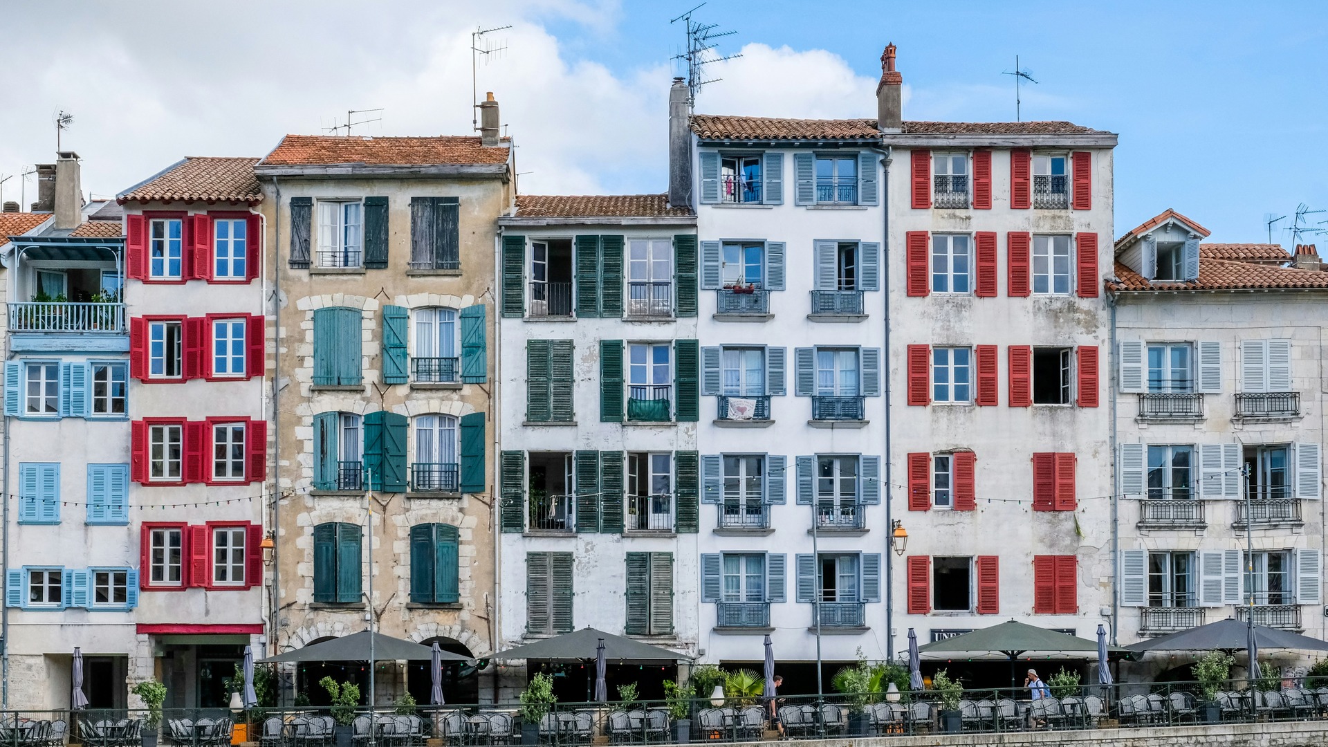 Fachadas con contraventanas de colores en Bayona junto al paseo del río.