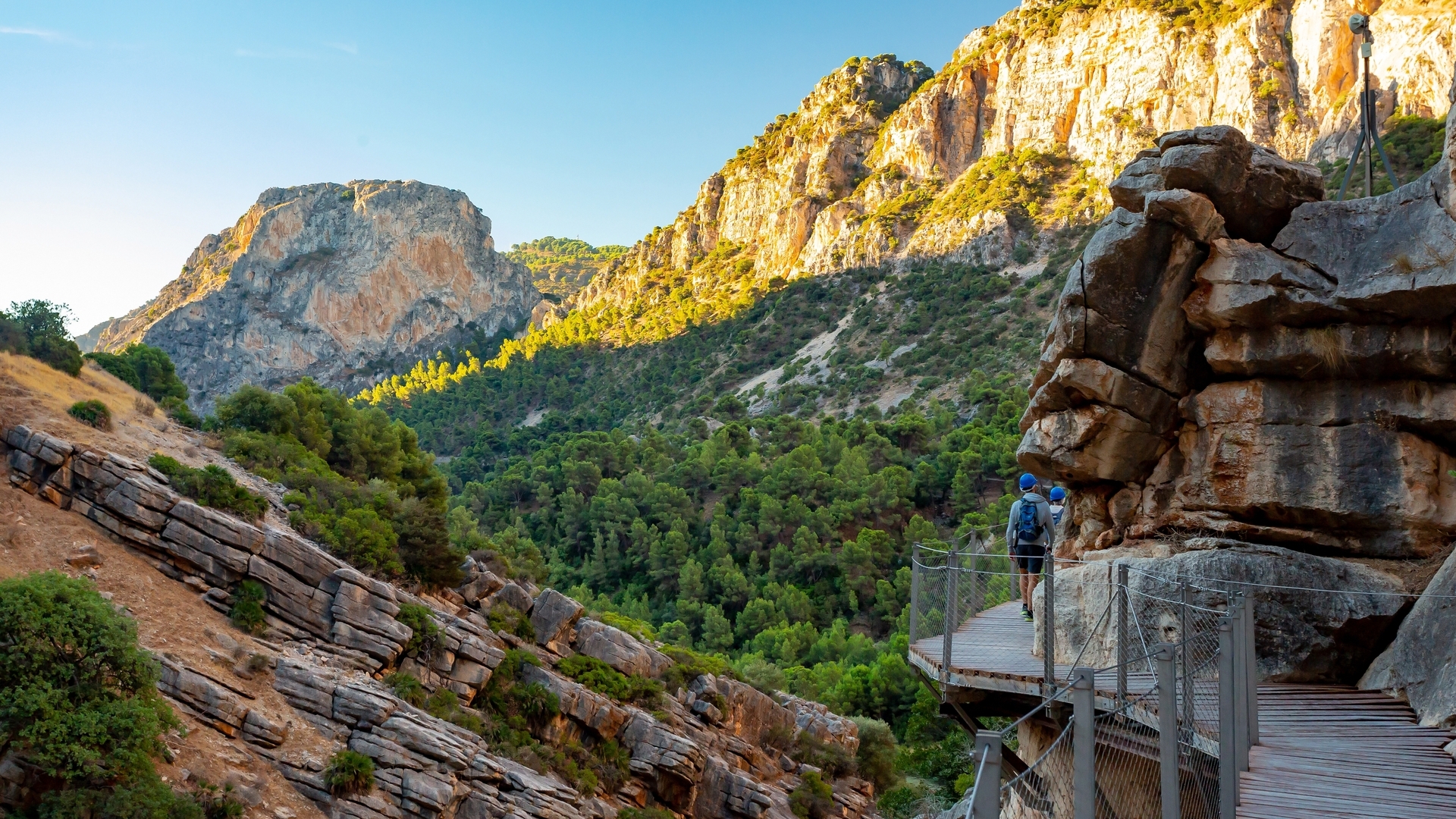 Senderistas por la pasarela de madera en el entorno natural del Caminito del Rey