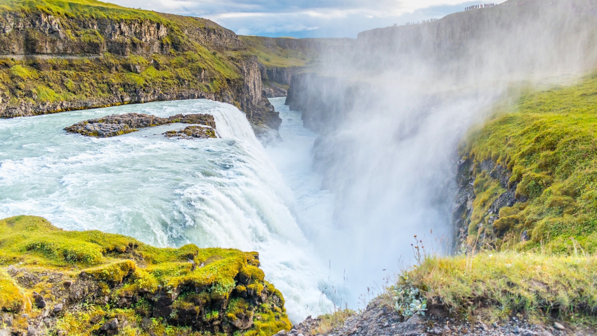 Catarata Gullfoss en Islandia, una de las más impresionantes del Círculo Dorado, rodeada de verdes acantilados.