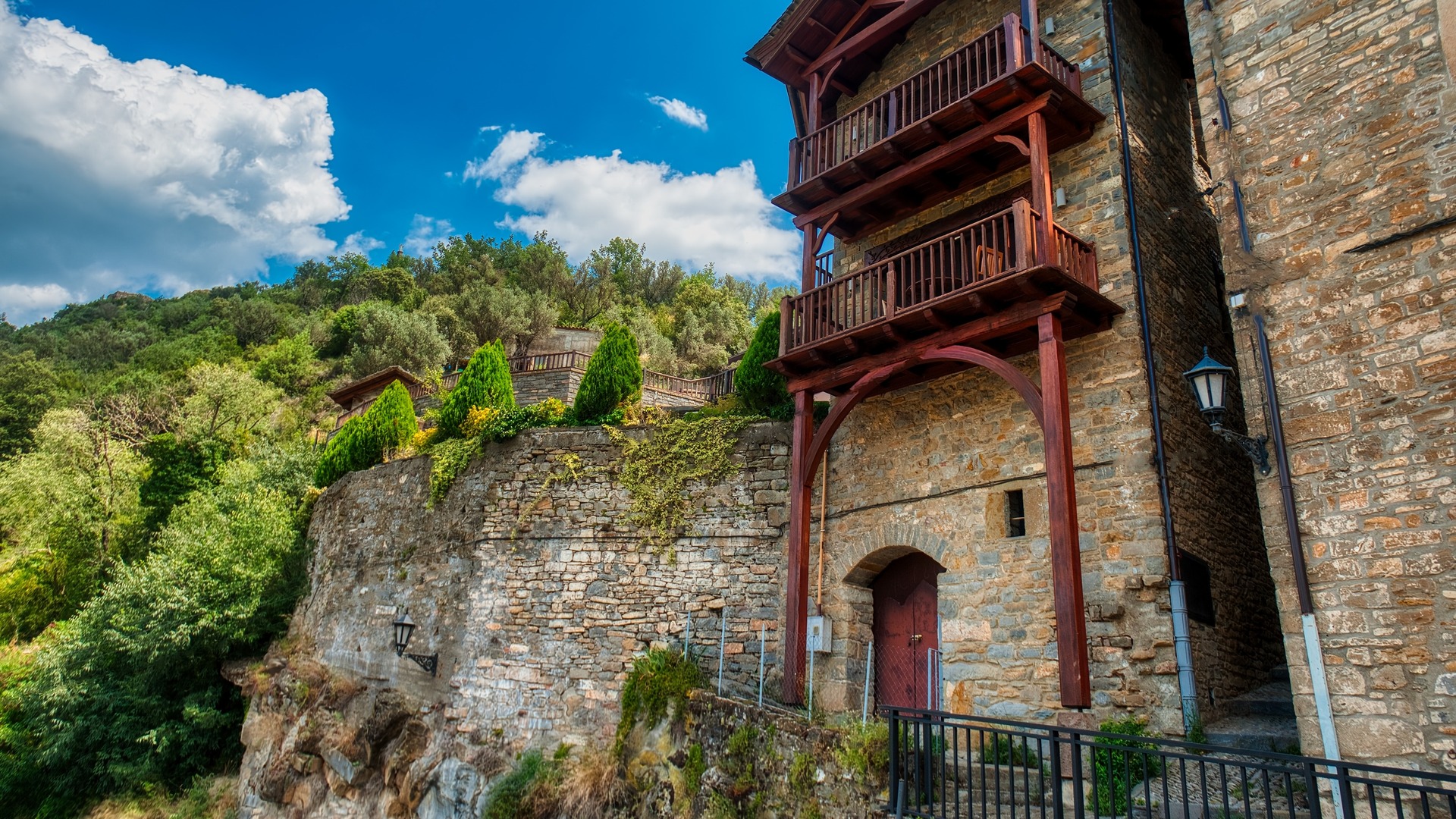 Edificio de piedra tradicional con balcones de madera en un acantilado de Aínsa.