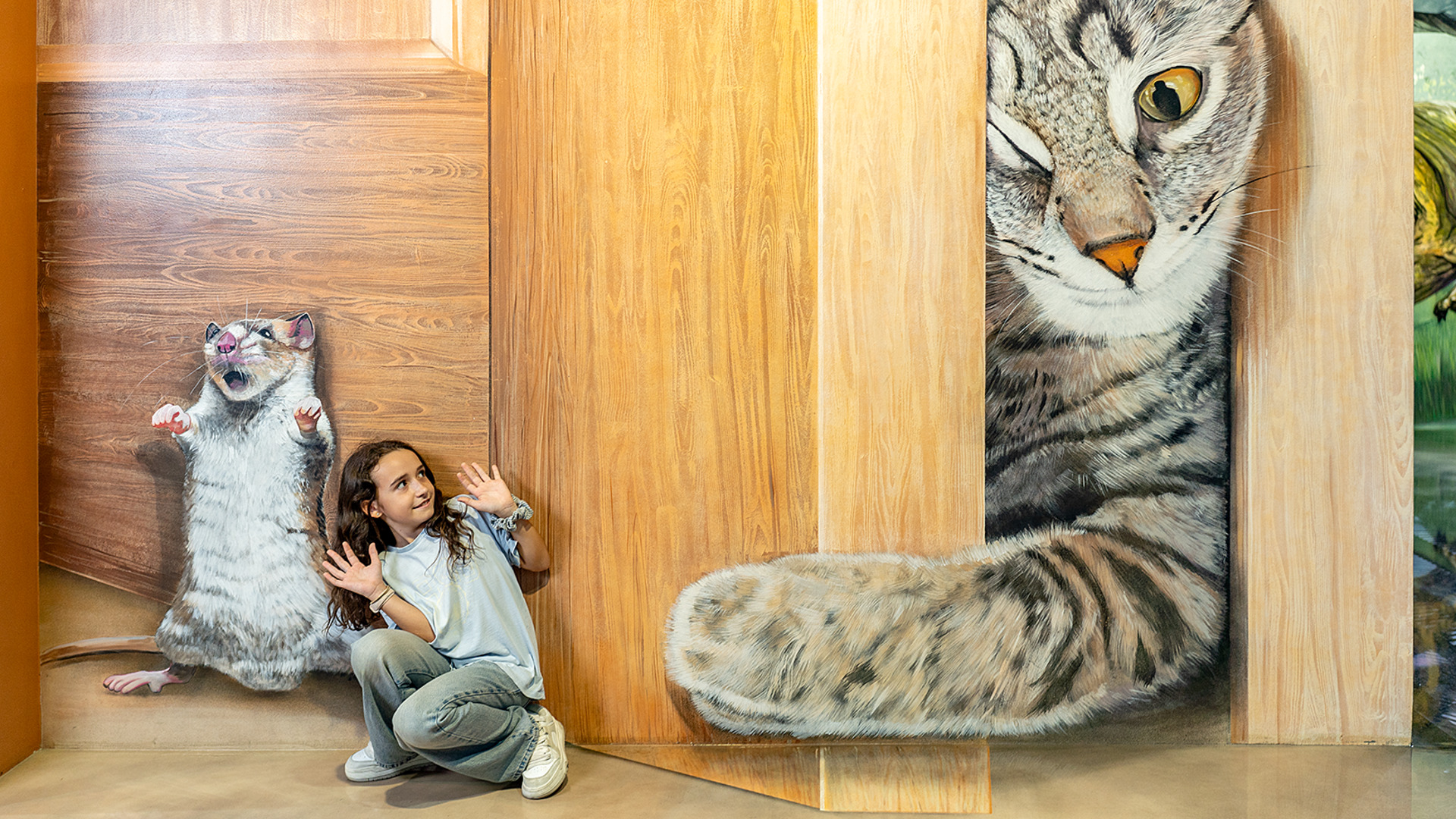 Niña posando con mural 3D de gato y ratón en el Museo de Ilusiones de Barcelona