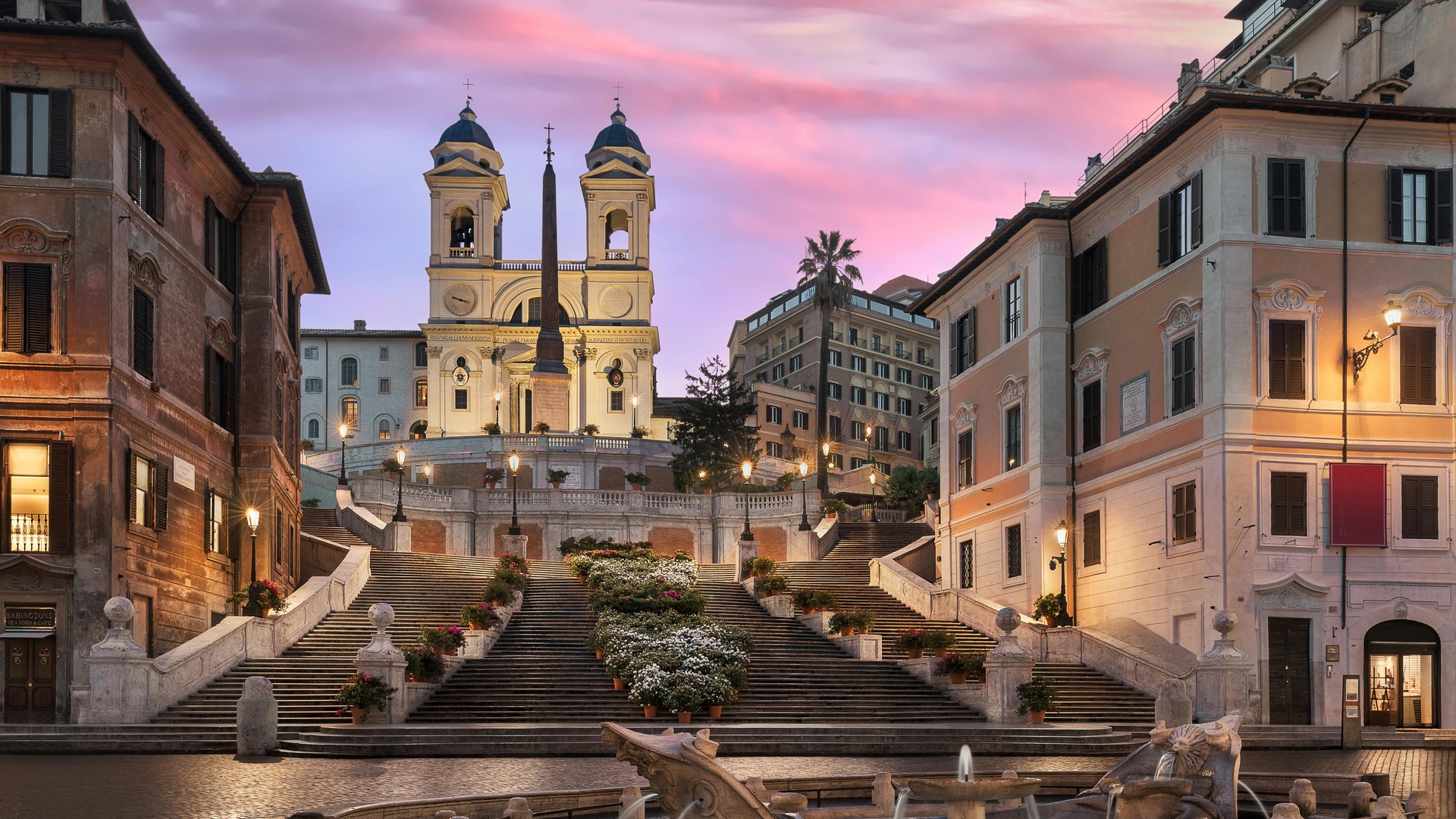 Escalinata de la Plaza de España y la iglesia Trinità dei Monti al ocaso en Roma.