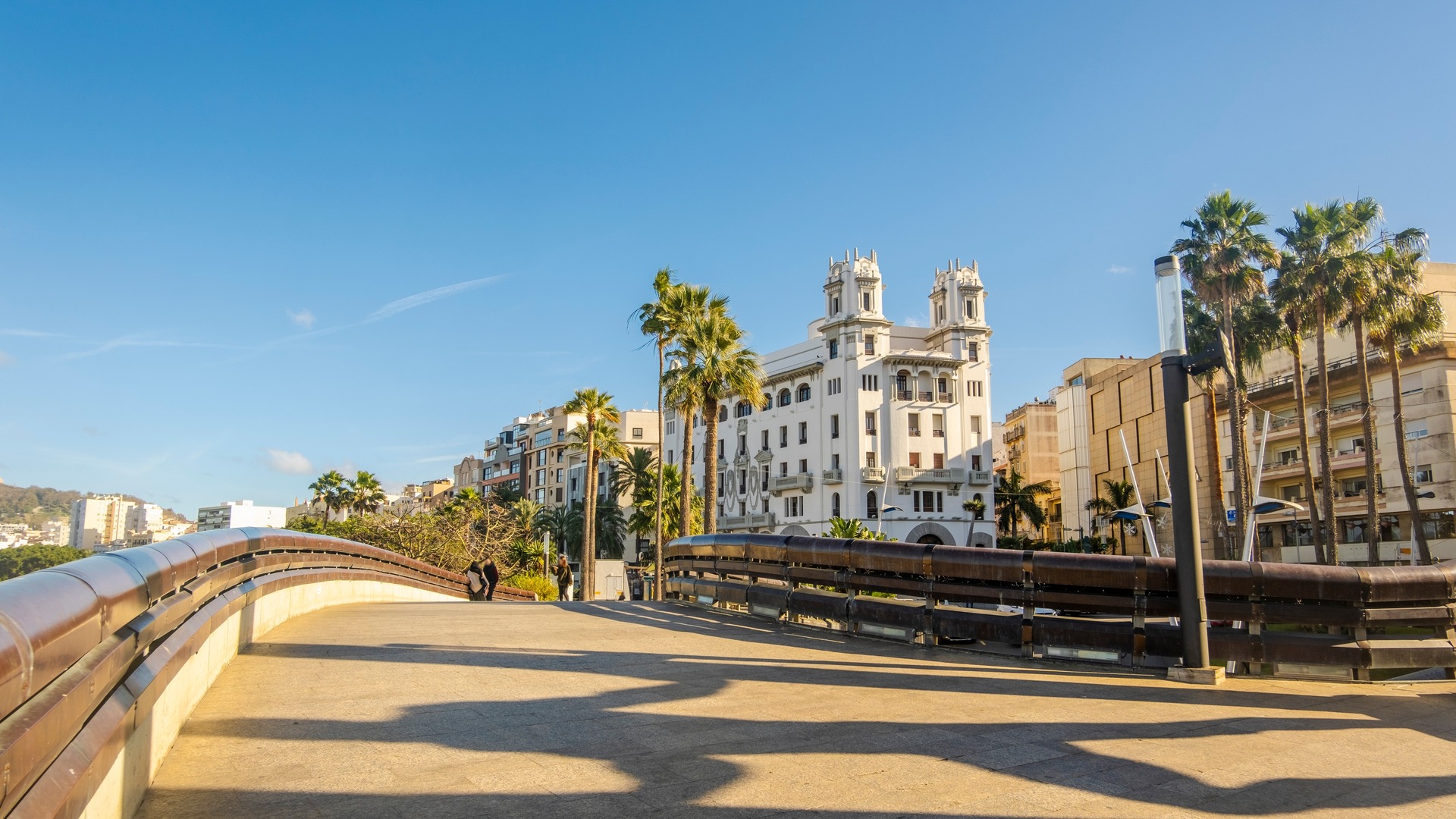Puente urbano con palmeras y edificio histórico en el centro de Ceuta