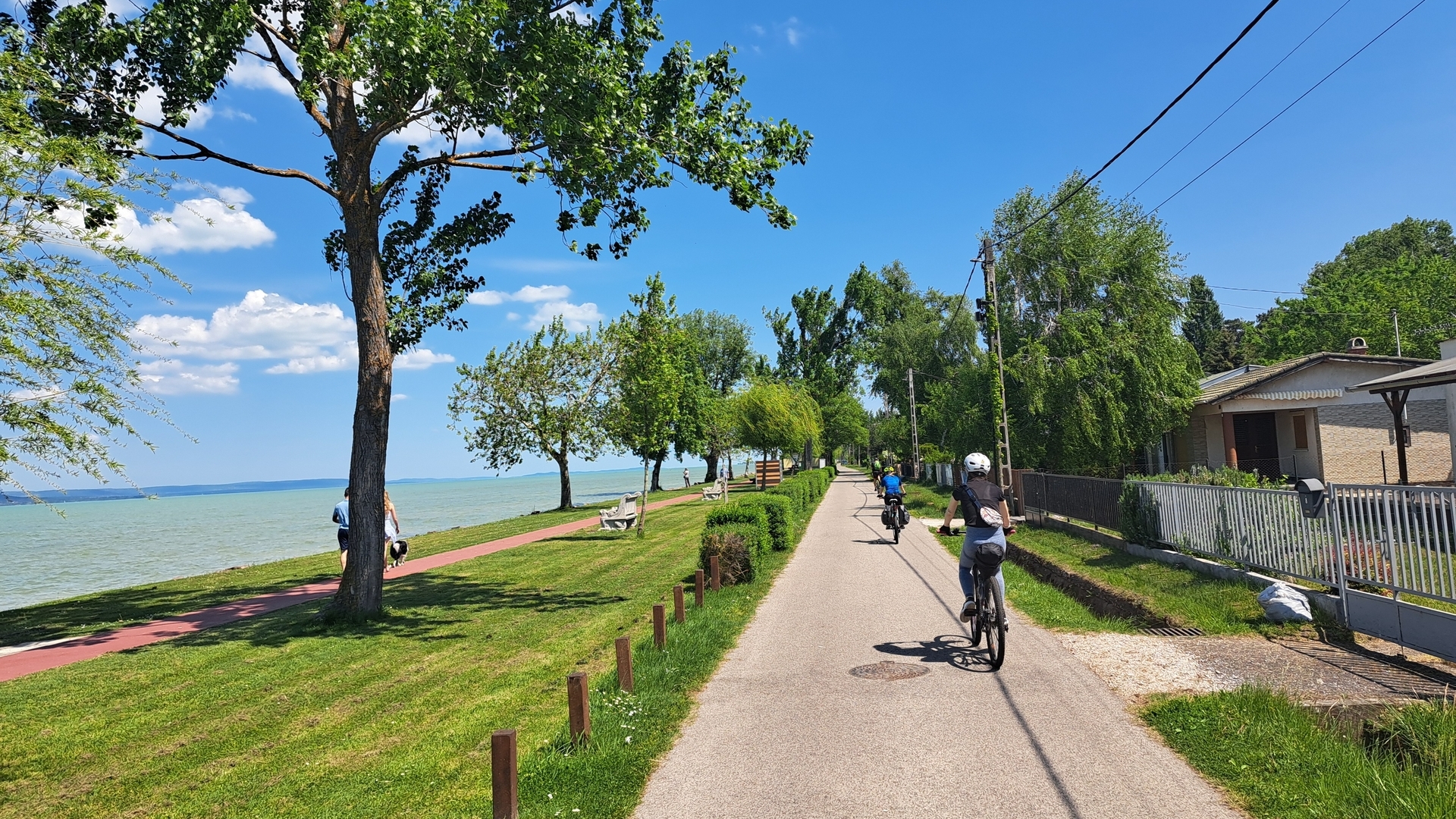 Ciclistas junto al paseo del lago Balaton en un día soleado