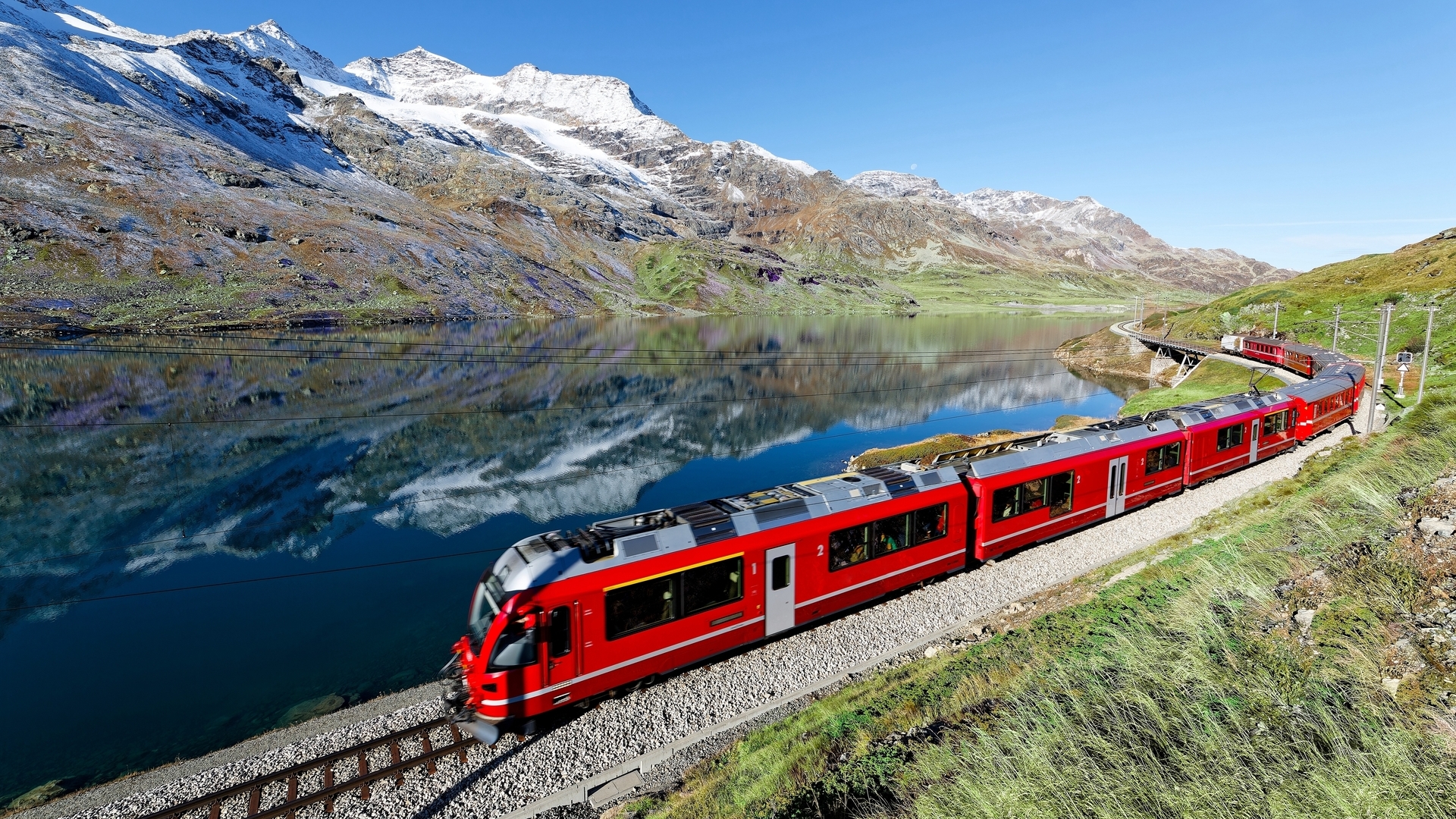 Bernina Express recorriendo los Alpes Suizos junto al lago en la ruta alpina