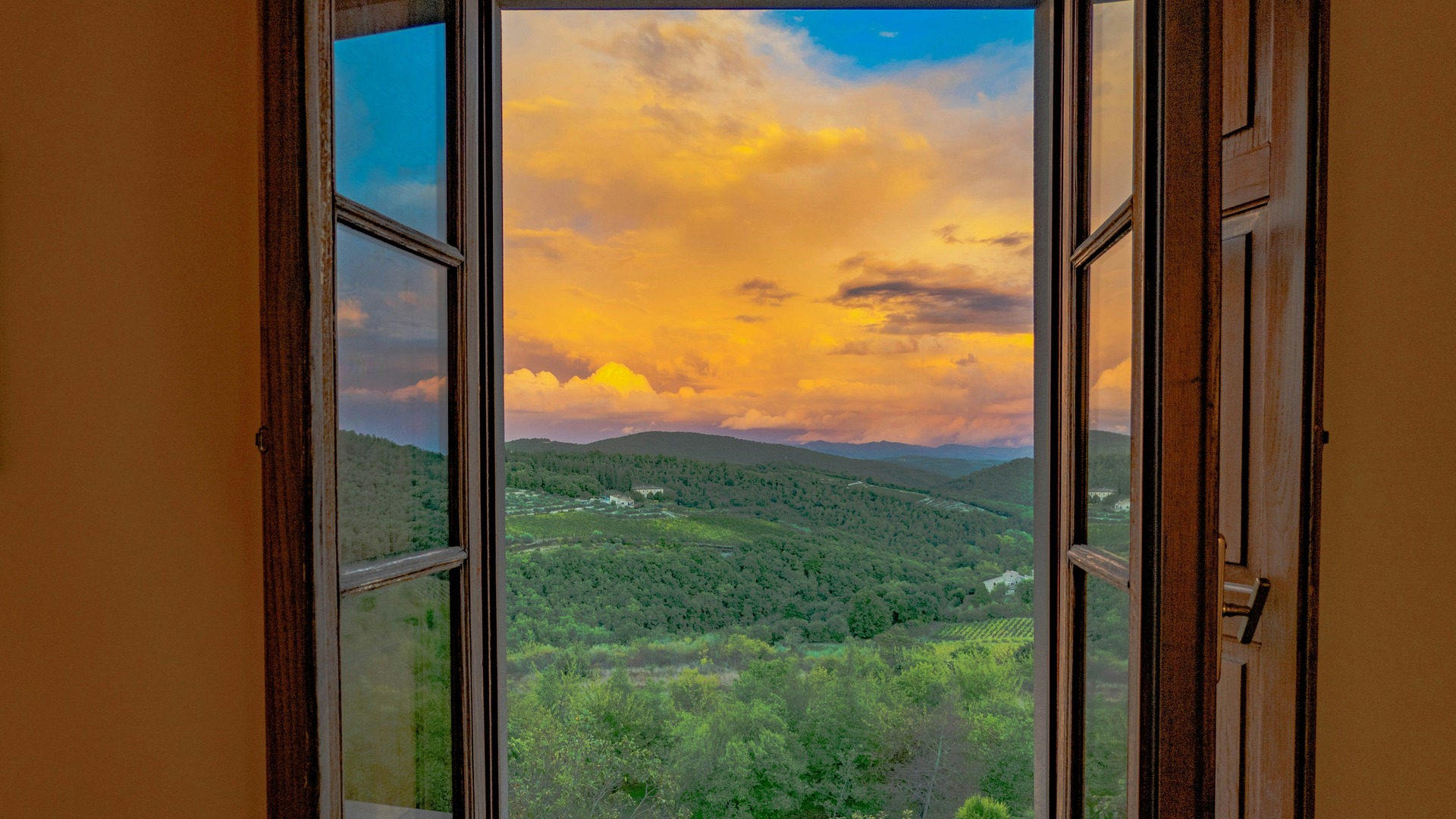 Atardecer sobre las colinas de la Toscana visto desde una ventana